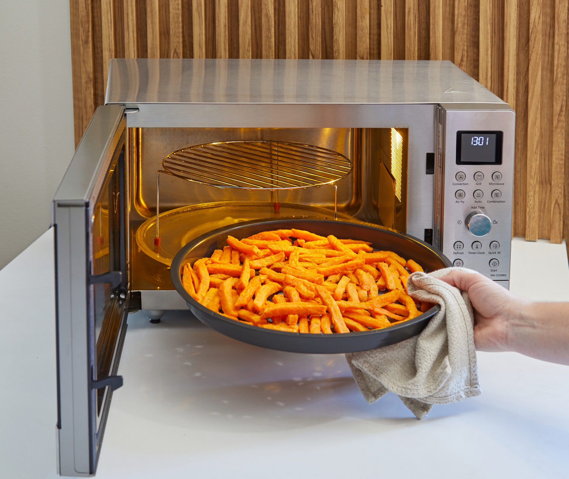 Panasonic NN-CT57RMEPG Panasonic NN-CT57RM kuchenka mikrofalowa Inverter Slim z grillem i funkcją Air Fry (1000W, termoobieg, 27l, kosz do smażenia beztłuszczowego), srebrna 37 Taca z frytkami wkładana do kuchenki Panasonic Slim Line Combi, z widocznym rusztem na górnym poziomie.