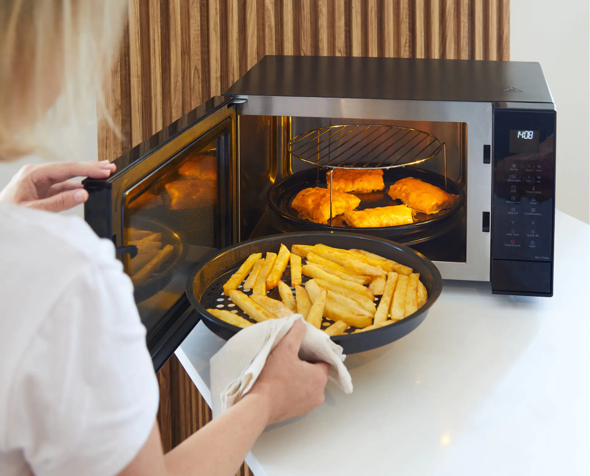 Panasonic NN-CT55RWEPG Panasonic NN-CT55RW kuchenka mikrofalowa Inverter Slim z grillem i funkcją Air Fry (1000 W, termoobieg, 27l, kosz do smażenia beztłuszczowego), biała 36 Taca z frytkami wkładana do kuchenki, podczas gdy ryba piecze się na ruszcie powyżej.